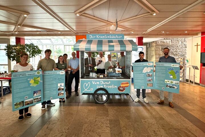 Landrat Wilhelm Schneider eröffnete gemeinsam mit Regionalmanagerin Sonja Gerstenkorn, der Produktionsfirma Kühnel17 sowie Vertreterinnen und Vertretern der vier Gemeinde-Allianzen das neue Krapfenbäcker-Infomobil. Foto: Jens Weinkauf/Landratsamt Haßberge.  