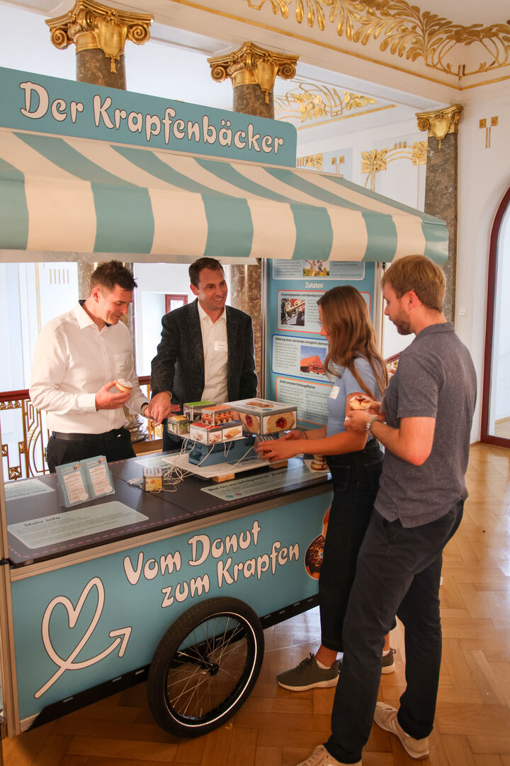 Mitarbeiter der Regierung am Krapfenbäckerstand.