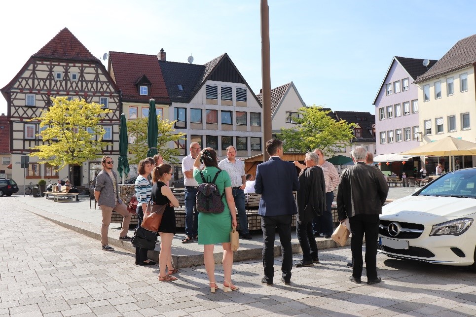 Bei der geführten Fußexkursion wurde auch der Marktplatz besichtigt, dessen Gestaltung das soziale Miteinander im öffentlichen Raum fördert. (Foto: Anne Weiß/Regierung von Unterfranken).